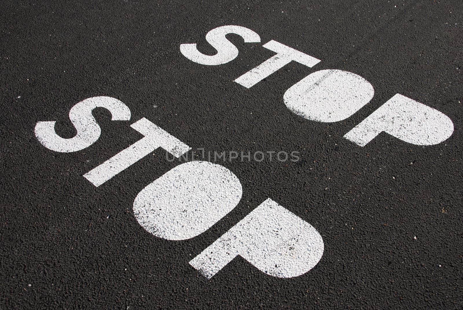 stop signs painted on a asphalt road surface

