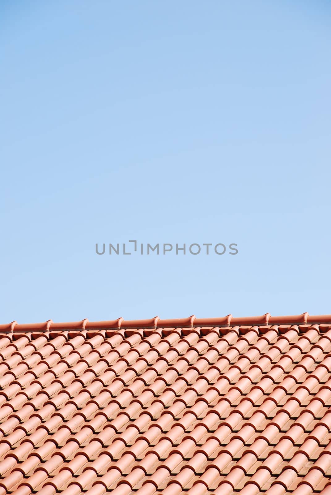 orange tiles on the roof of a house against blue sky background