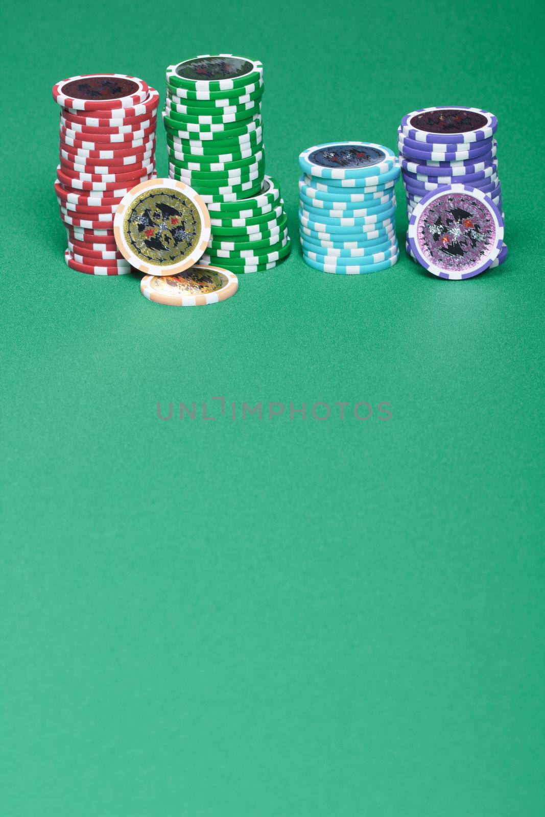 A stack of chips on a green playing a gambling table in a casino
