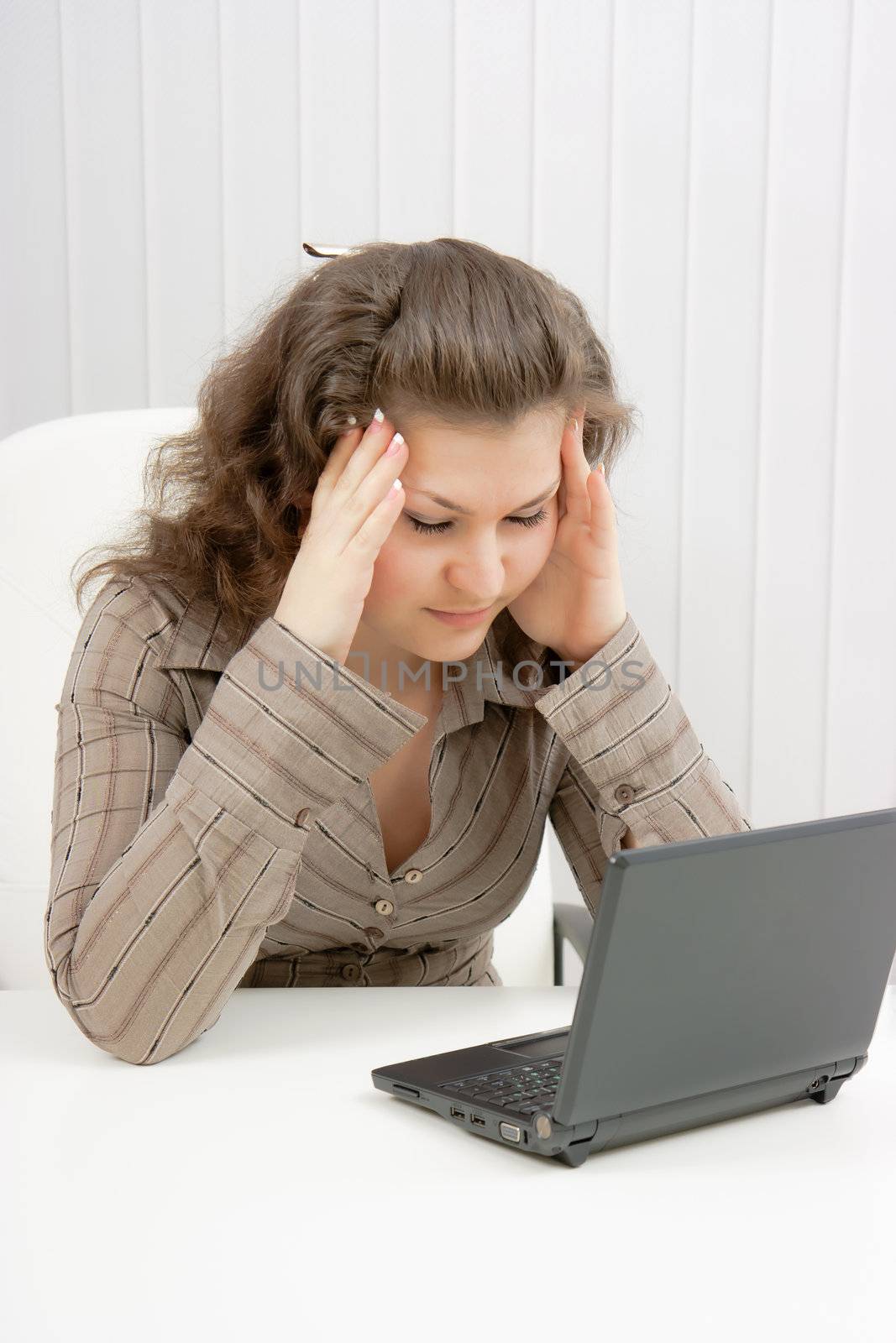 girl with laptop suffers from headaches. Office
