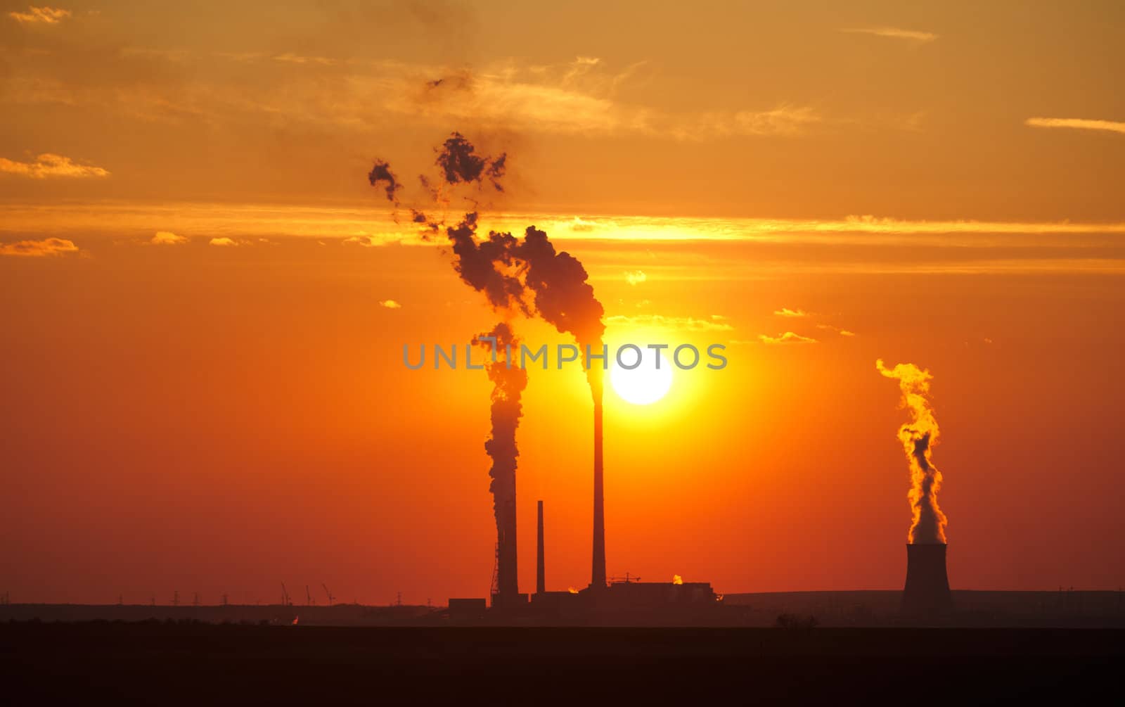 Large electric plant at sunset emitting poison in the air
