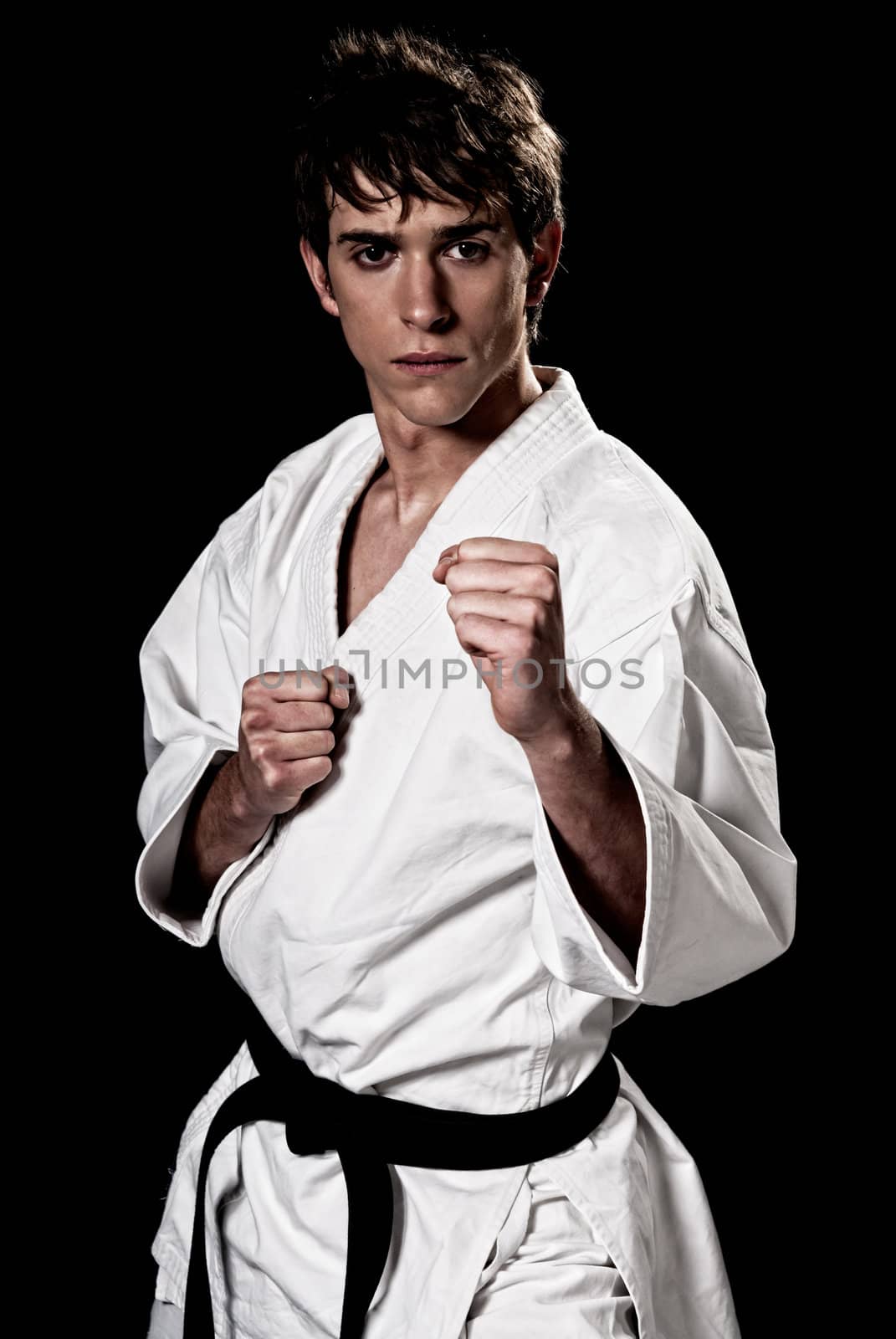 Karate male fighter young high contrast on black background. by dgmata