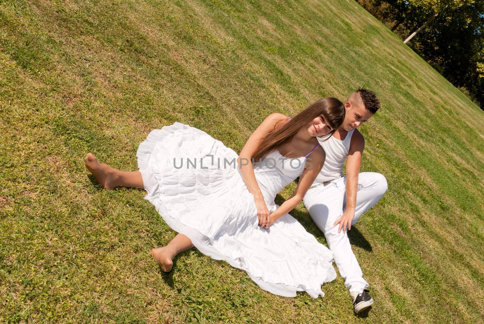 young couple happy sitting on grass white clothes, love relationship by dgmata