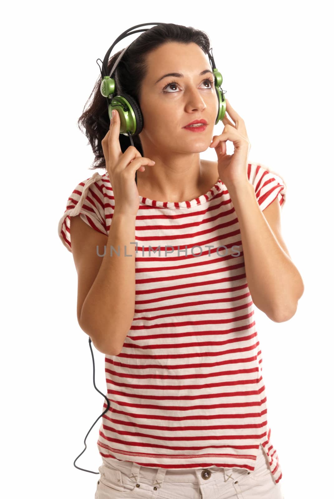 Young woman listening music with headphones standing on white background
