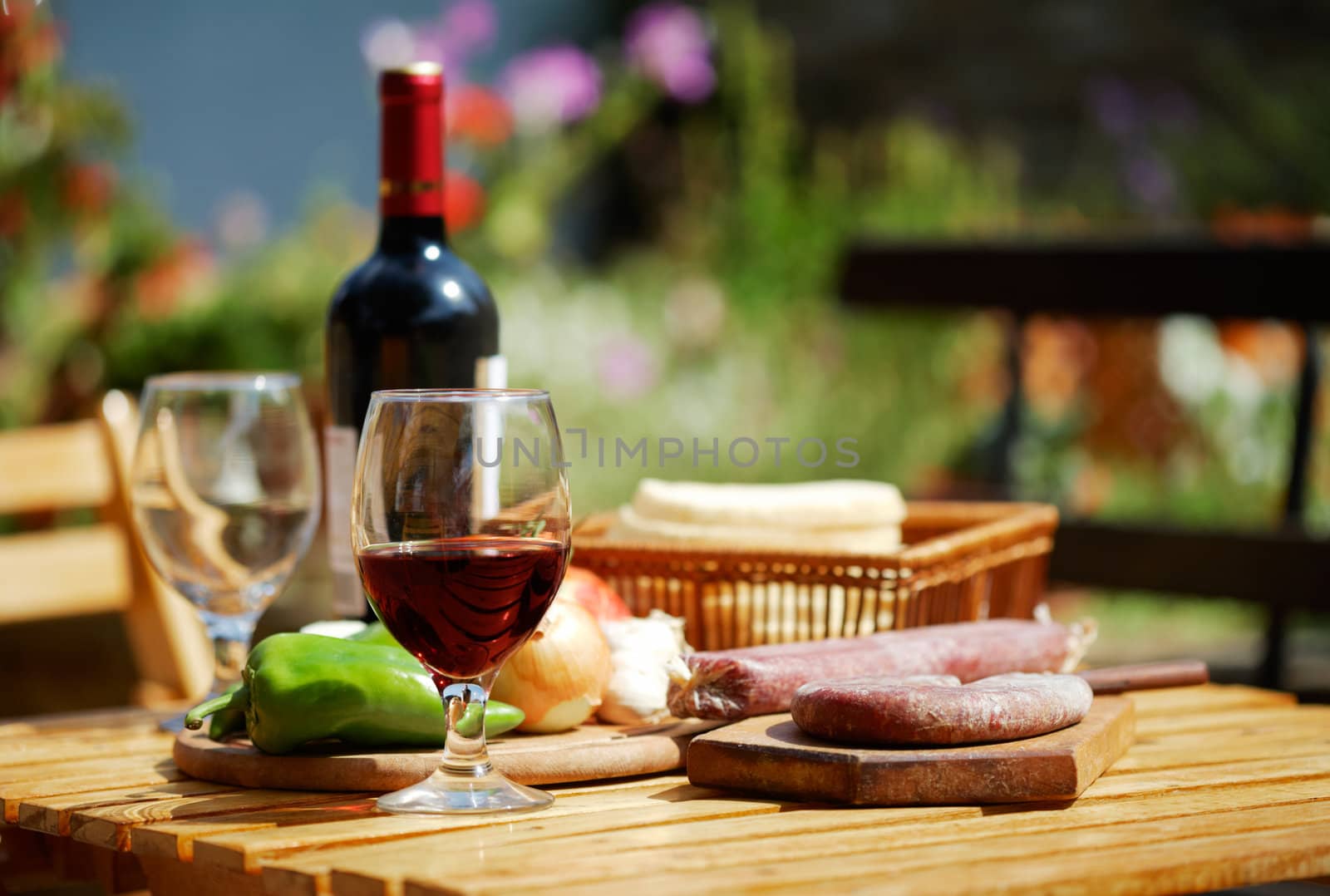 Table with red wine and tasty, delicipous food in the backyard