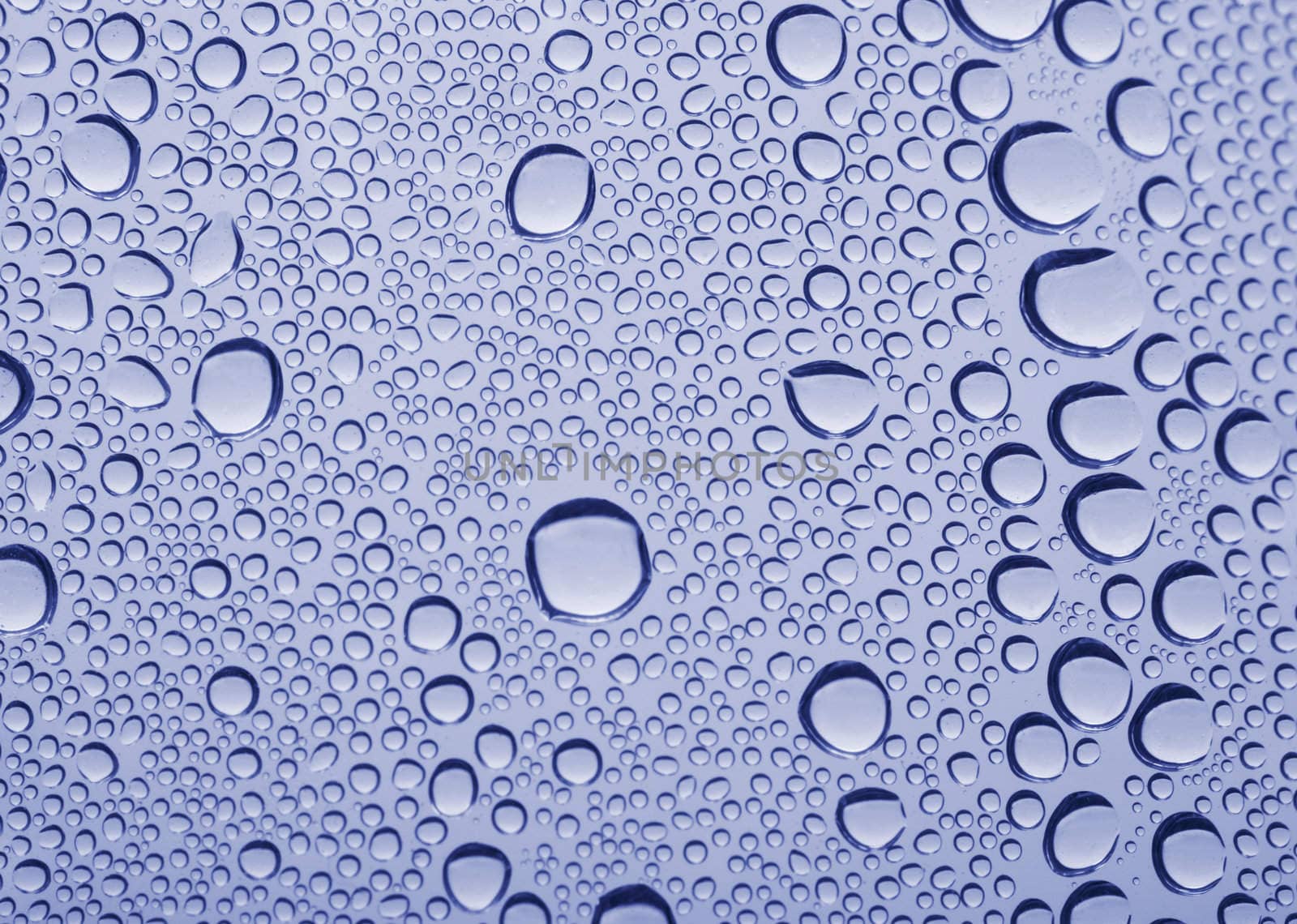 Bright water drops on glass texture