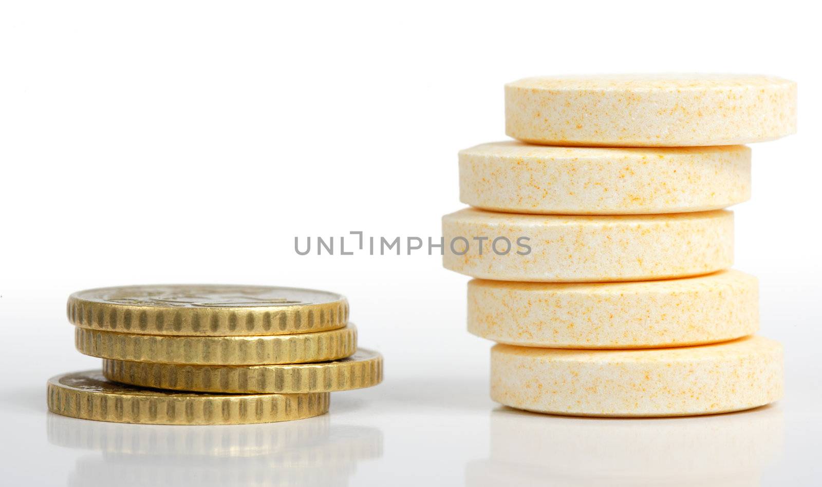 Heaps of pills and coins close-up