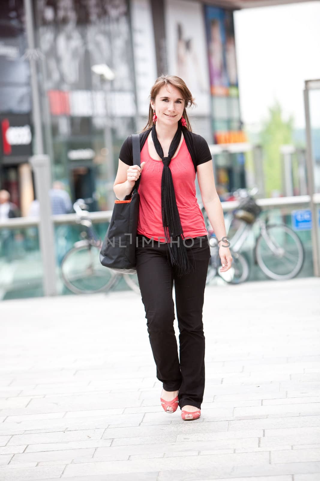 Beautiful young woman walking by Fotosmurf