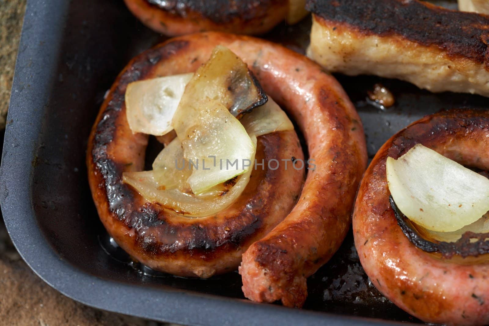 Baked sausage with onion on a grill