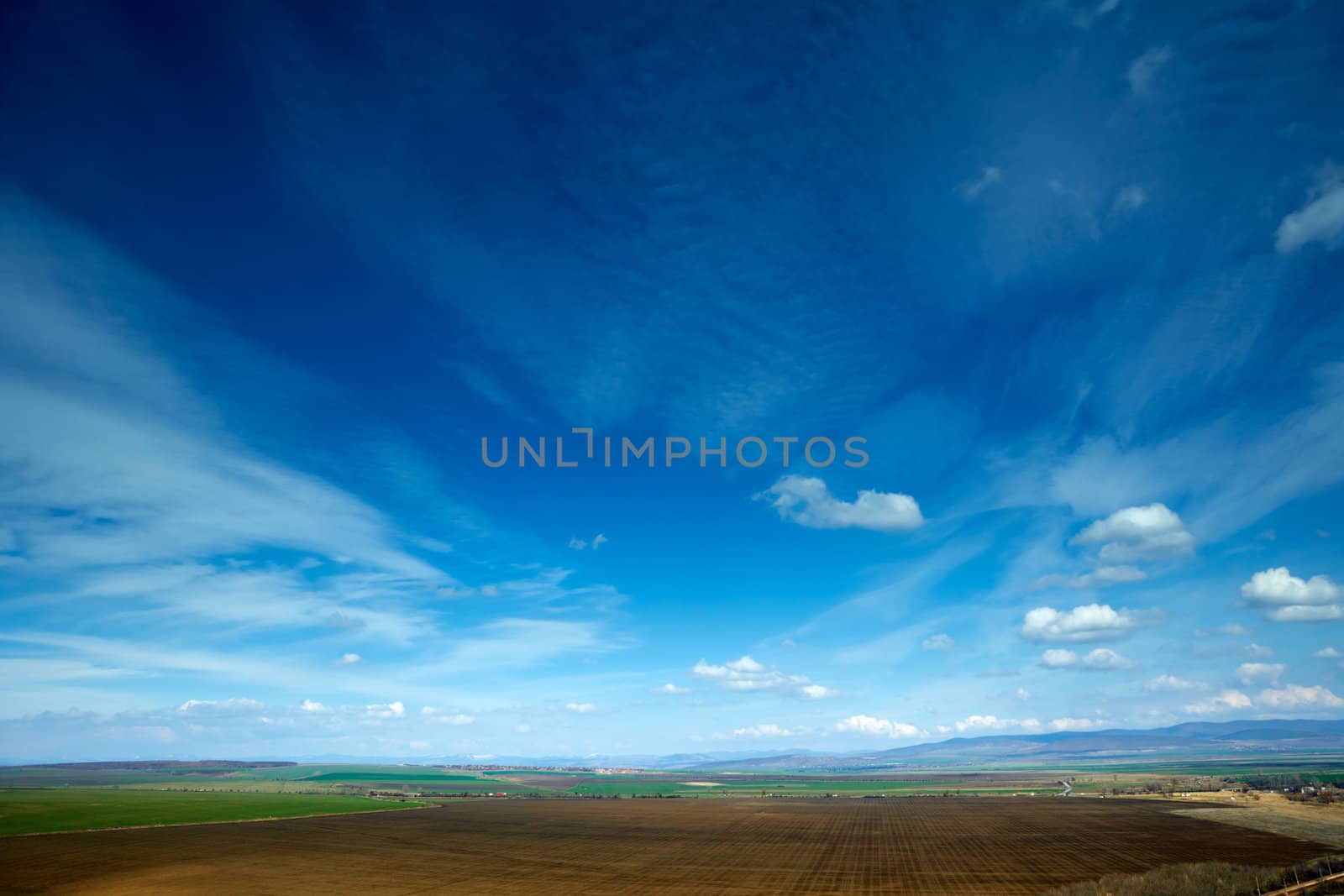 Spring landscape with beautiful colorful blue sky and strange clouds