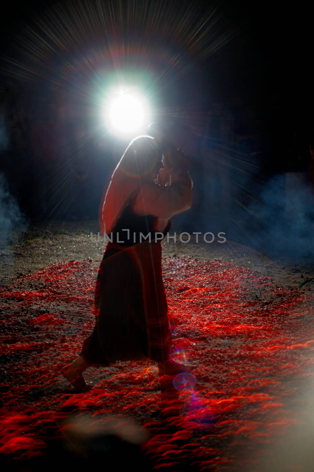 Bulgarian traditional Nestinari firedancer, a woman with icon in the hands dancing on live coals