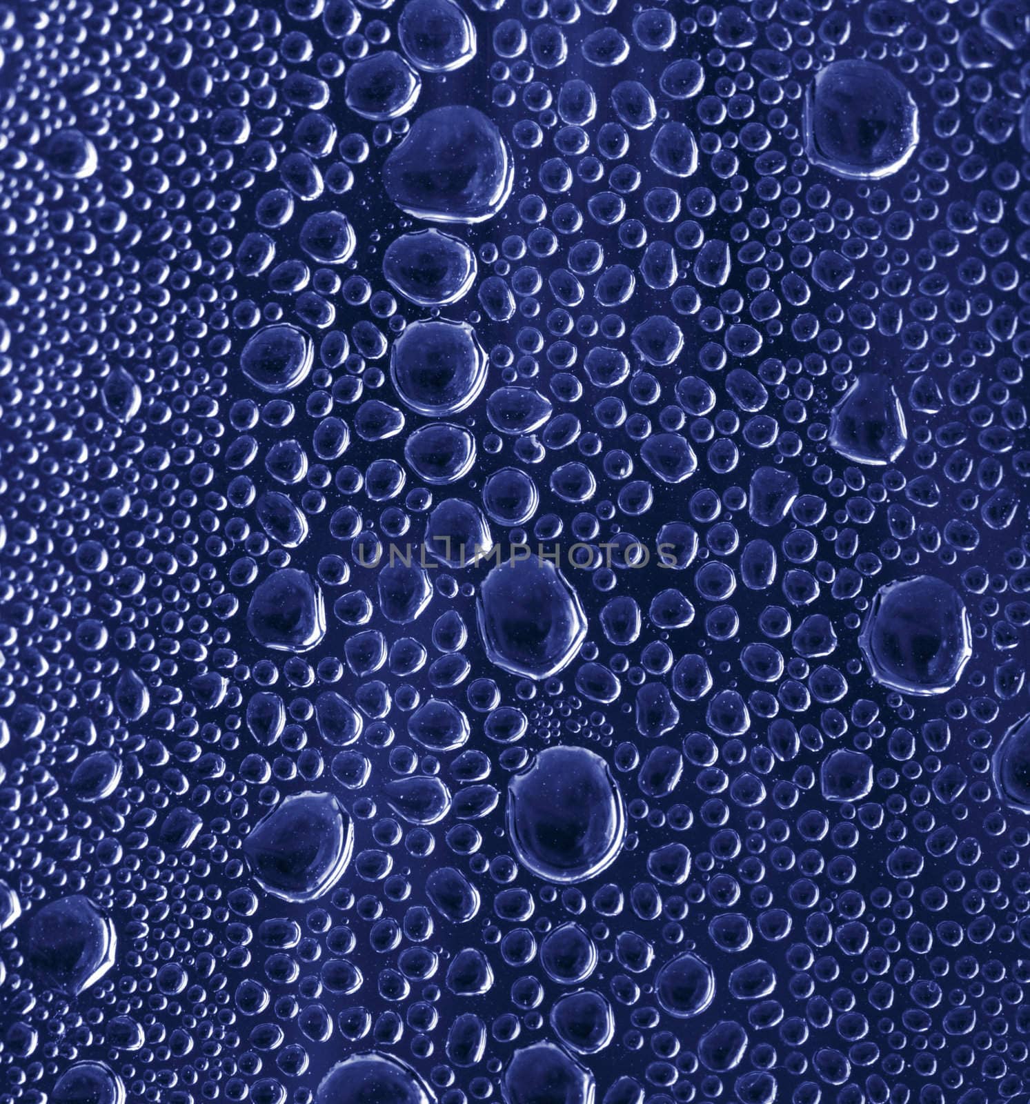 Blue water drops on glass background