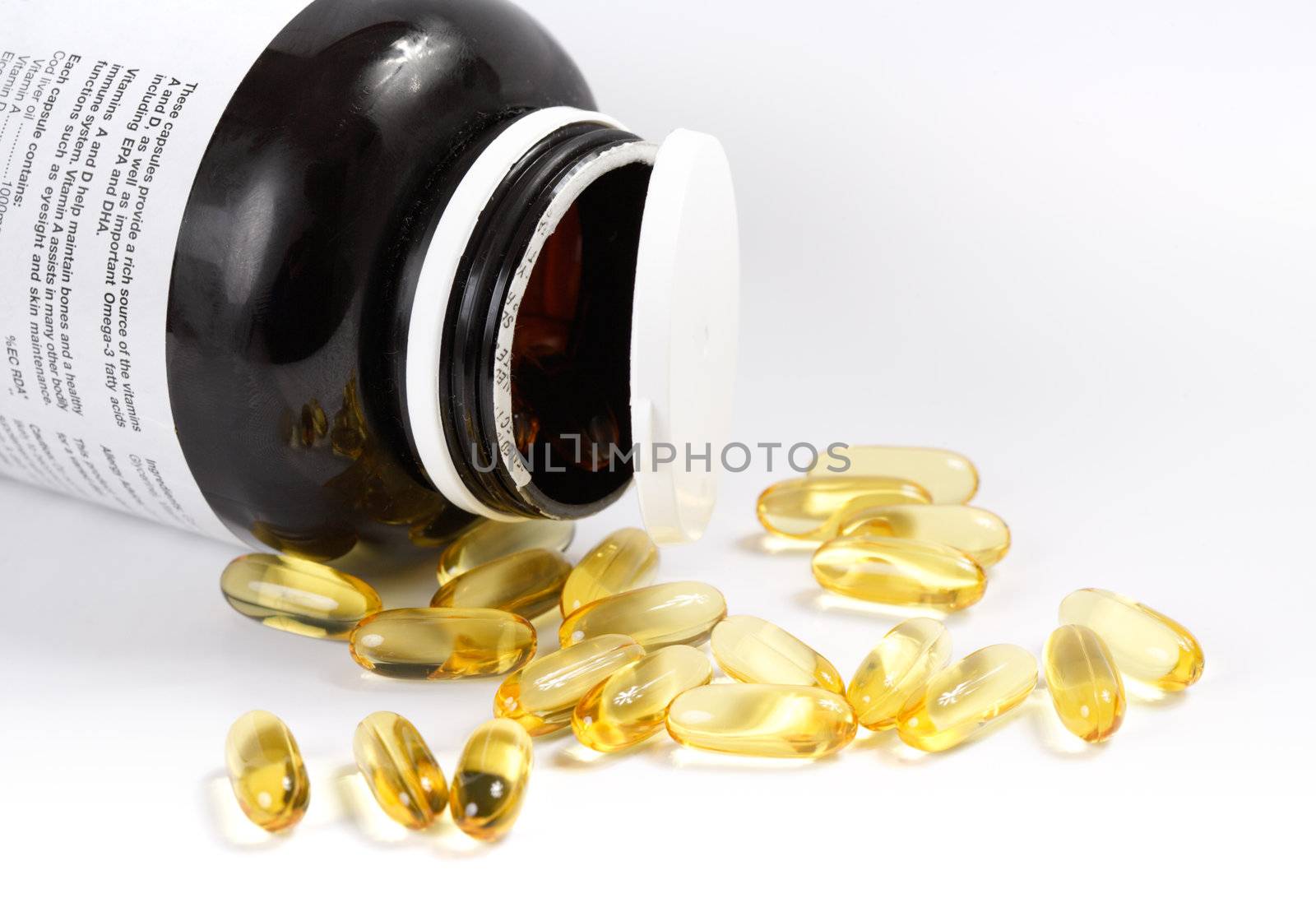 Transparent cod-liver pills spilled on a white background