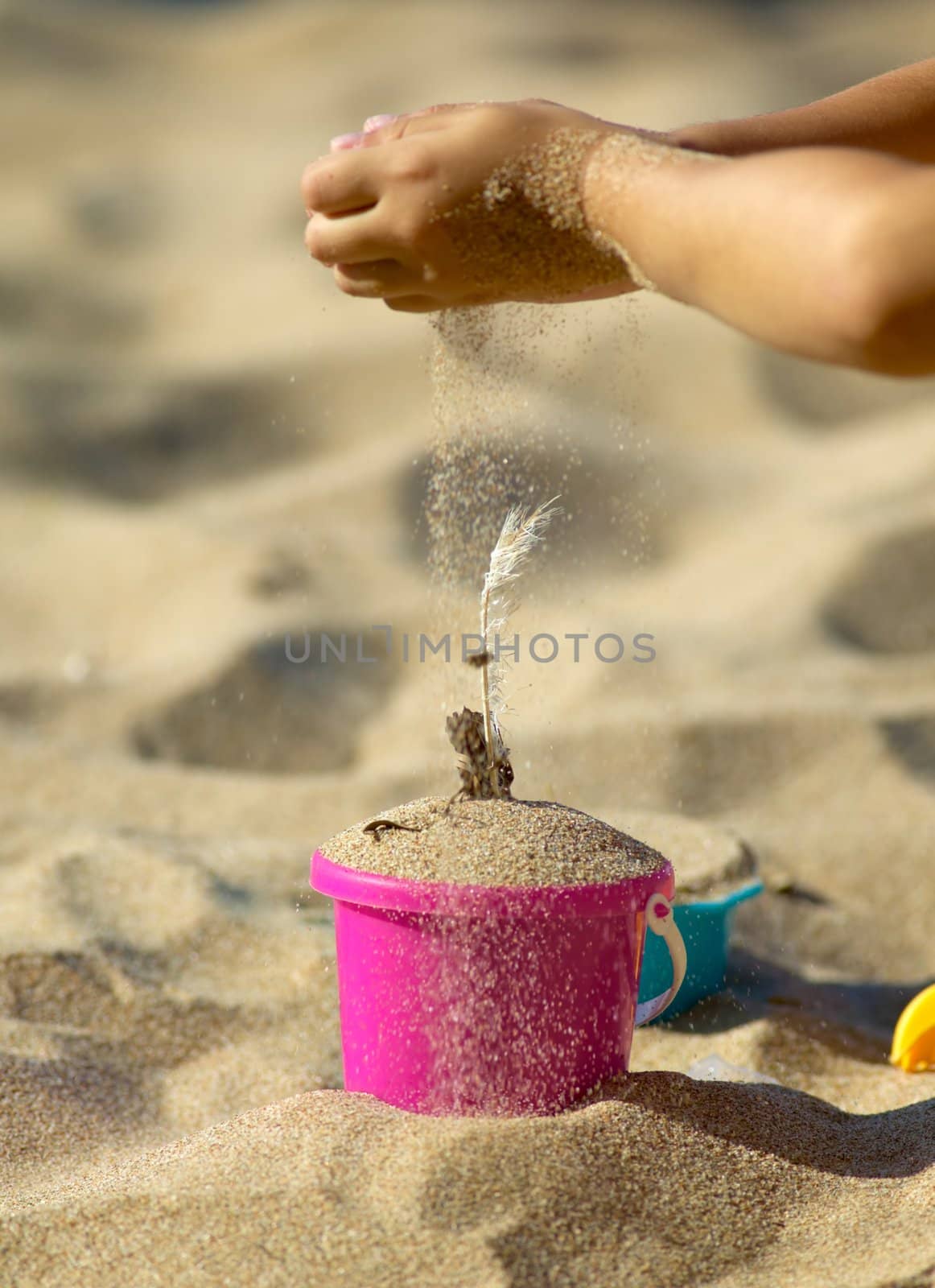 Child playing with sand on the beach