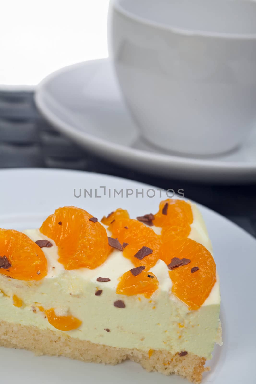 slice of tangerine cream cake on a white plate by bernjuer