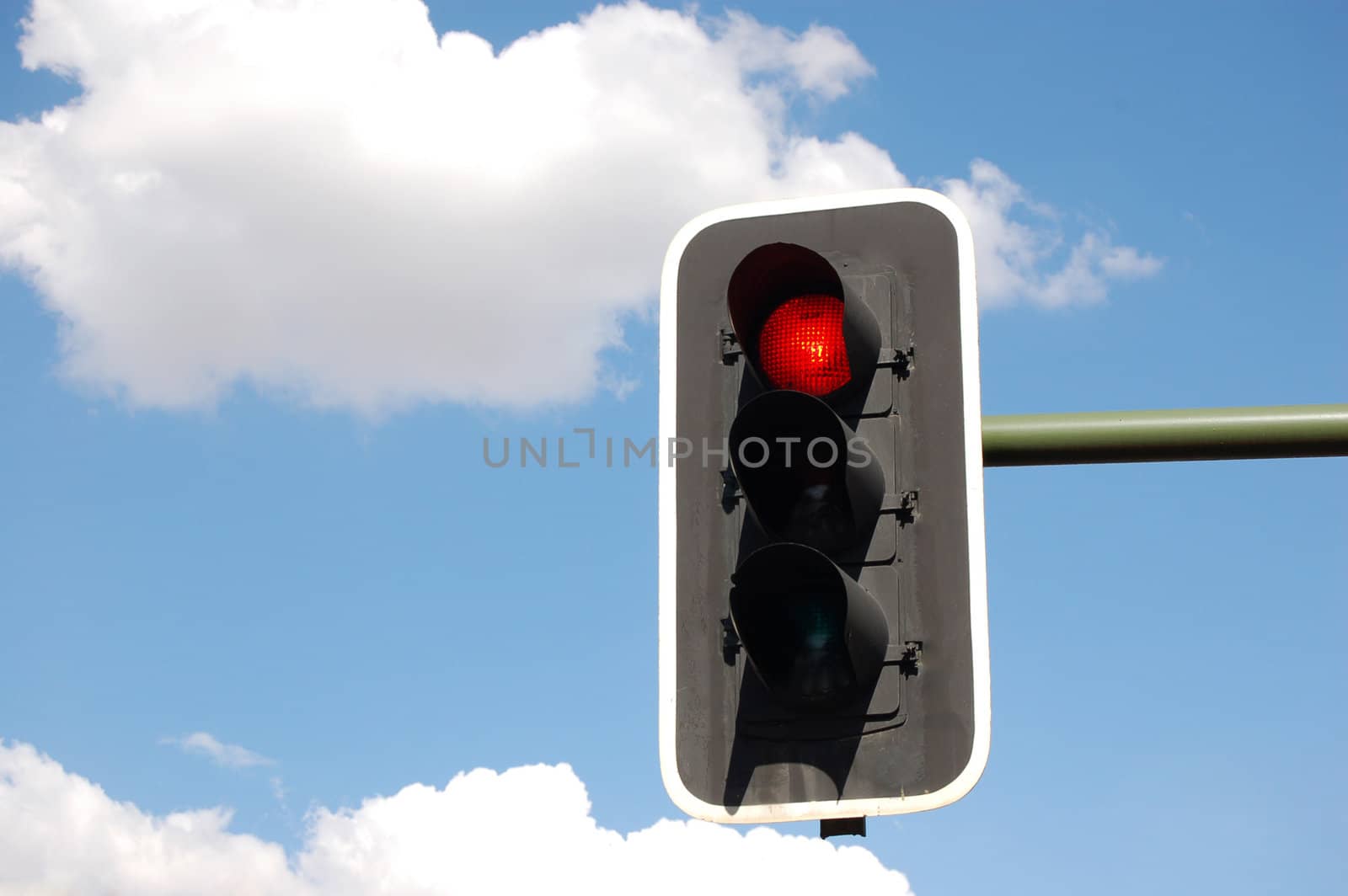 Red traffic light on perfect sky background