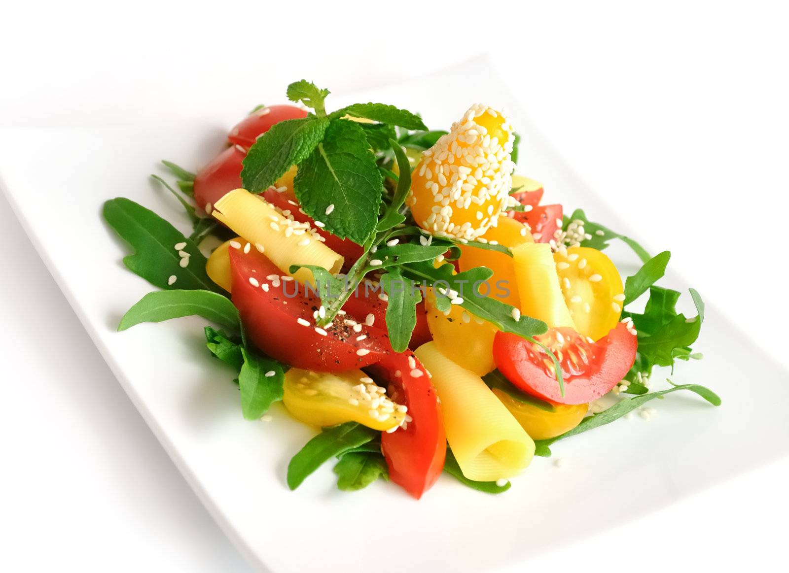 Salad of red and yellow tomato with cheese, arugula, sesame