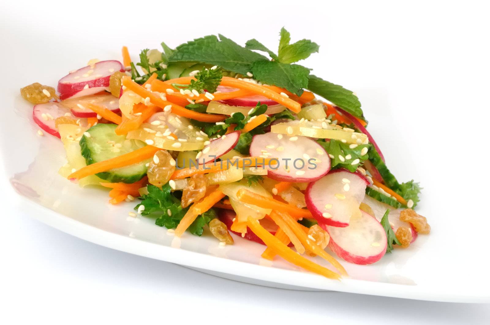 A salad of carrot, radish, cucumber, raisins, sesame and herbs