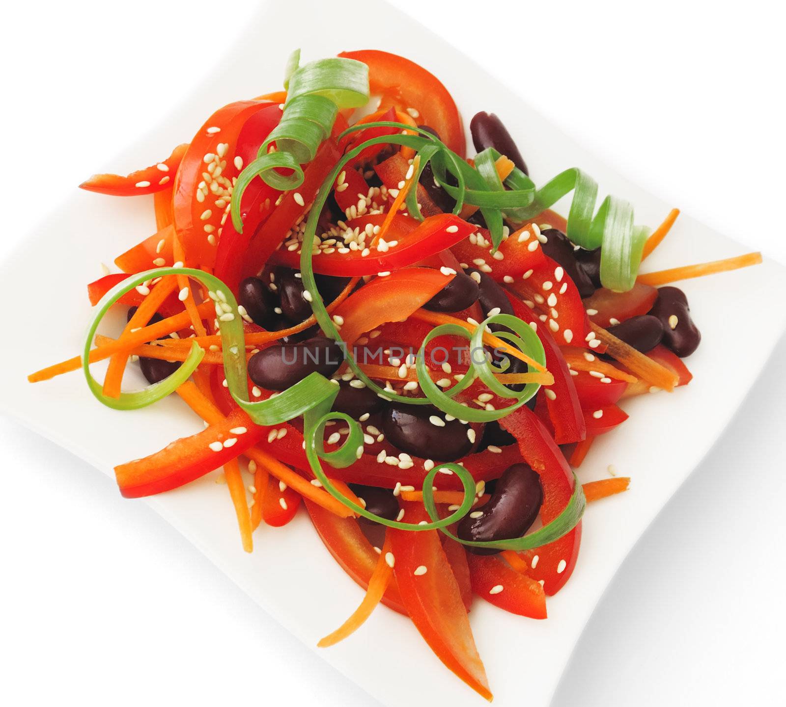 A salad of tomatoes, sweet peppers, red beans, carrots with sesame