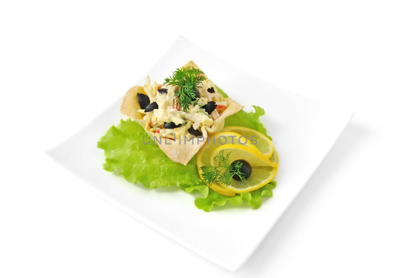 Salad with crab meat, egg, olives, mayonnaise in a basket isolated