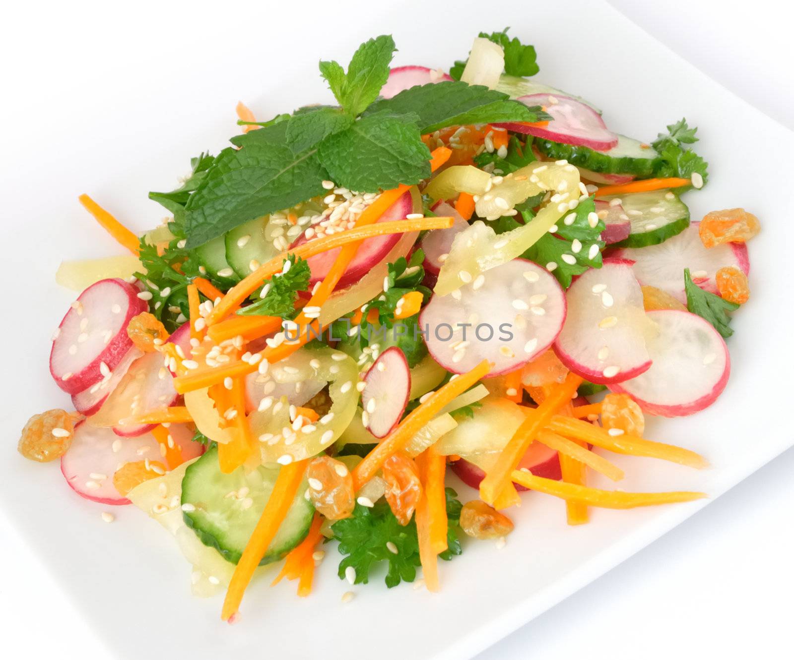 A salad of carrot, radish, cucumber, raisins, sesame and herbs