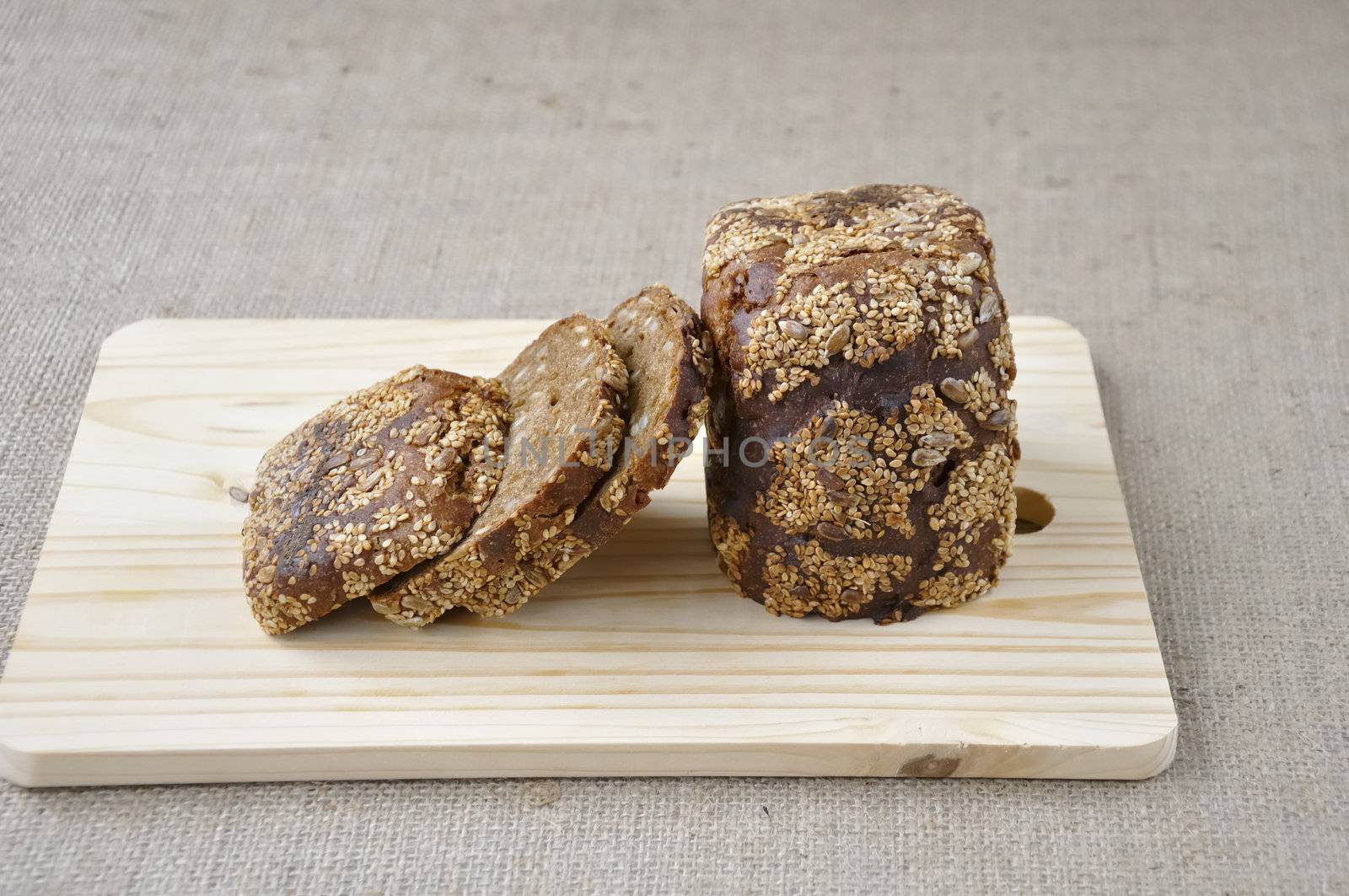 Rye bread with cereals cut pieces on a wooden board