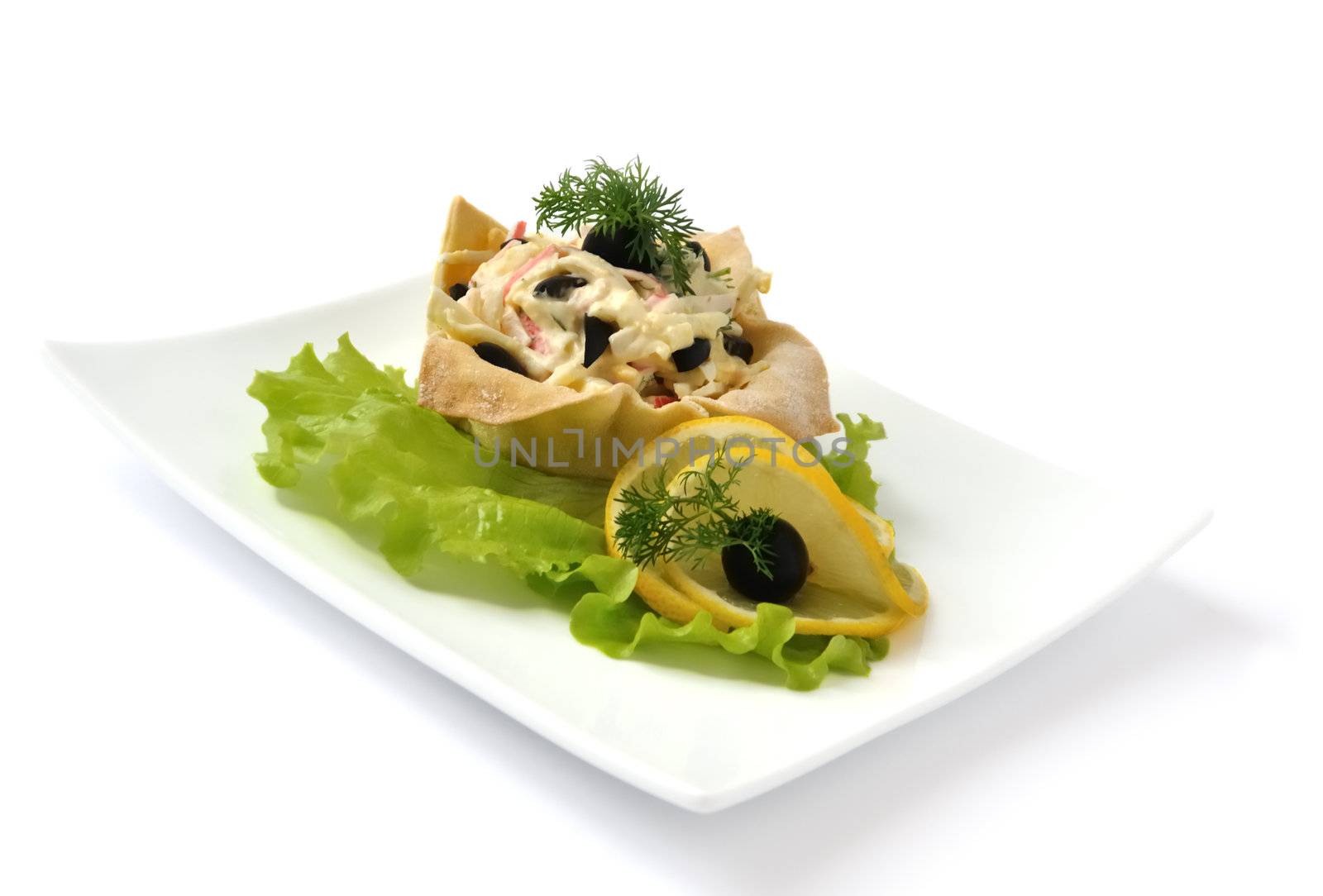 Salad with crab meat, egg, olives, mayonnaise in a basket isolated