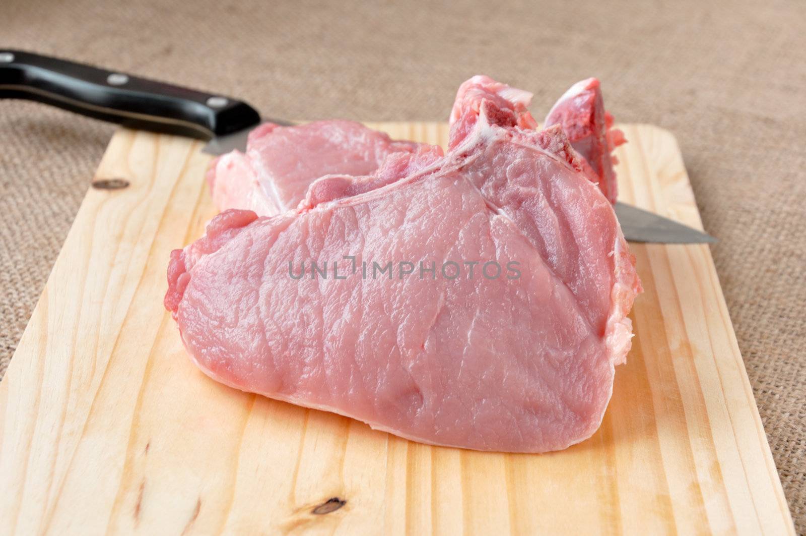 pieces of steak on the bone lying on a wooden board