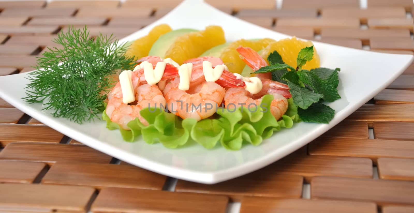 Appetizer of avocado and orange and shrimp with cream sauce