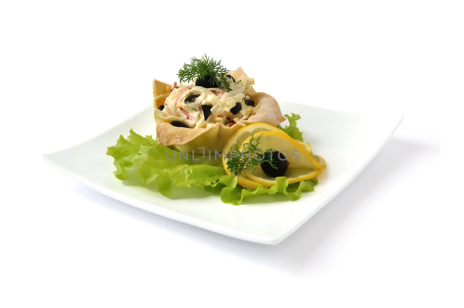 Salad with crab meat, egg, olives, mayonnaise in a basket isolated