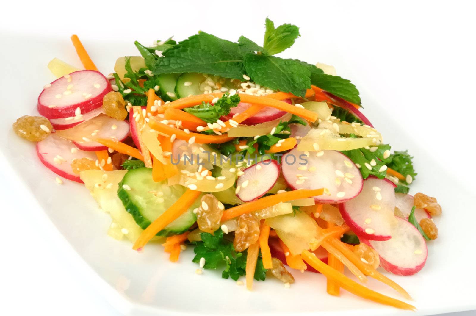 A salad of carrot, radish, cucumber, raisins, sesame and herbs