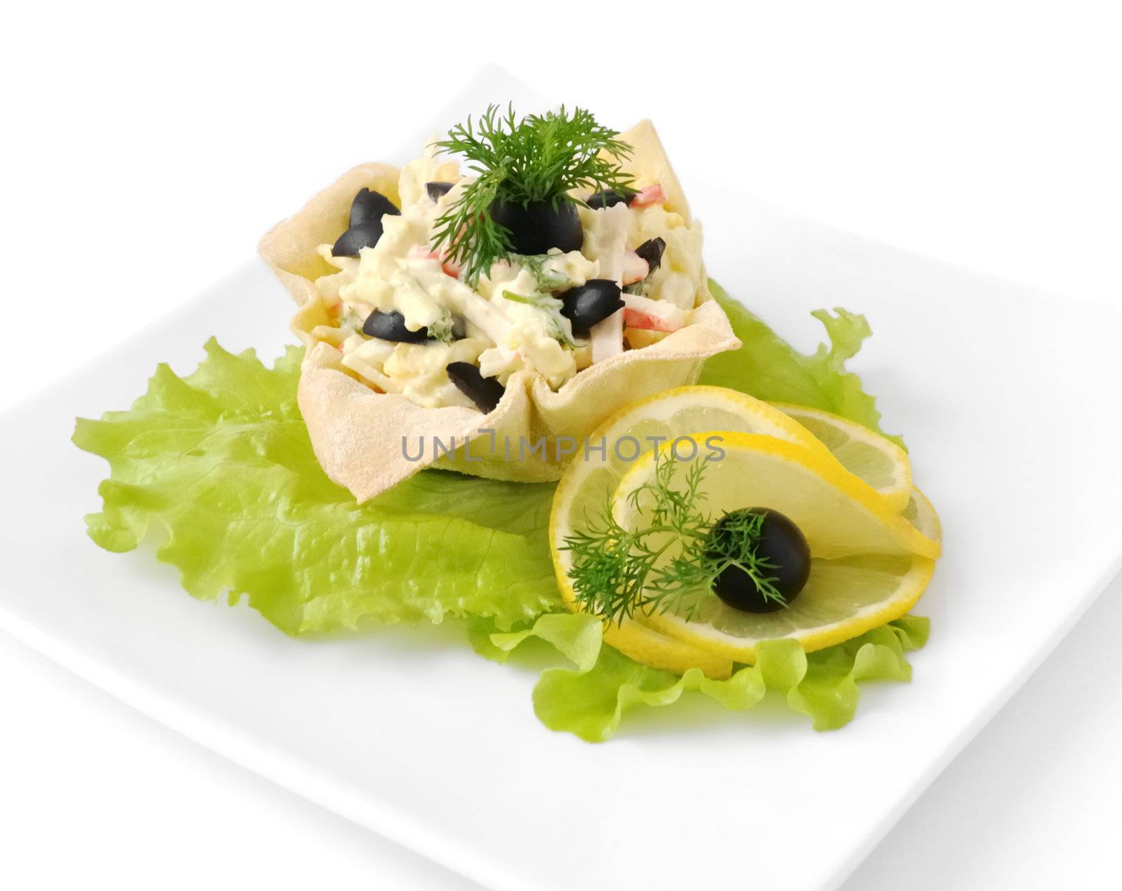 Salad with crab meat, egg, olives, mayonnaise in a basket isolated