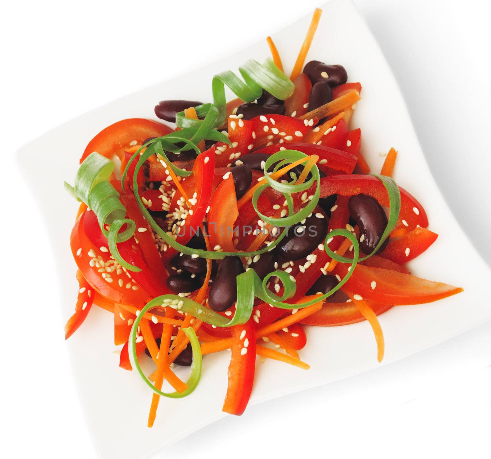 A salad of tomatoes, sweet peppers, red beans, carrots with sesame