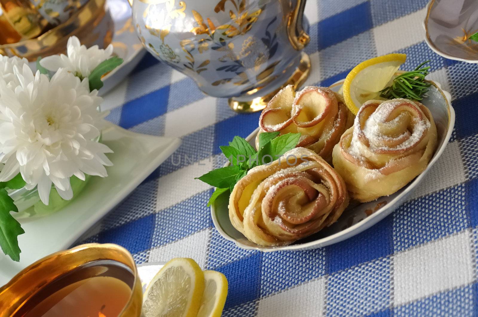 Rosettes of the apples and dough with powdered sugar to the tea table