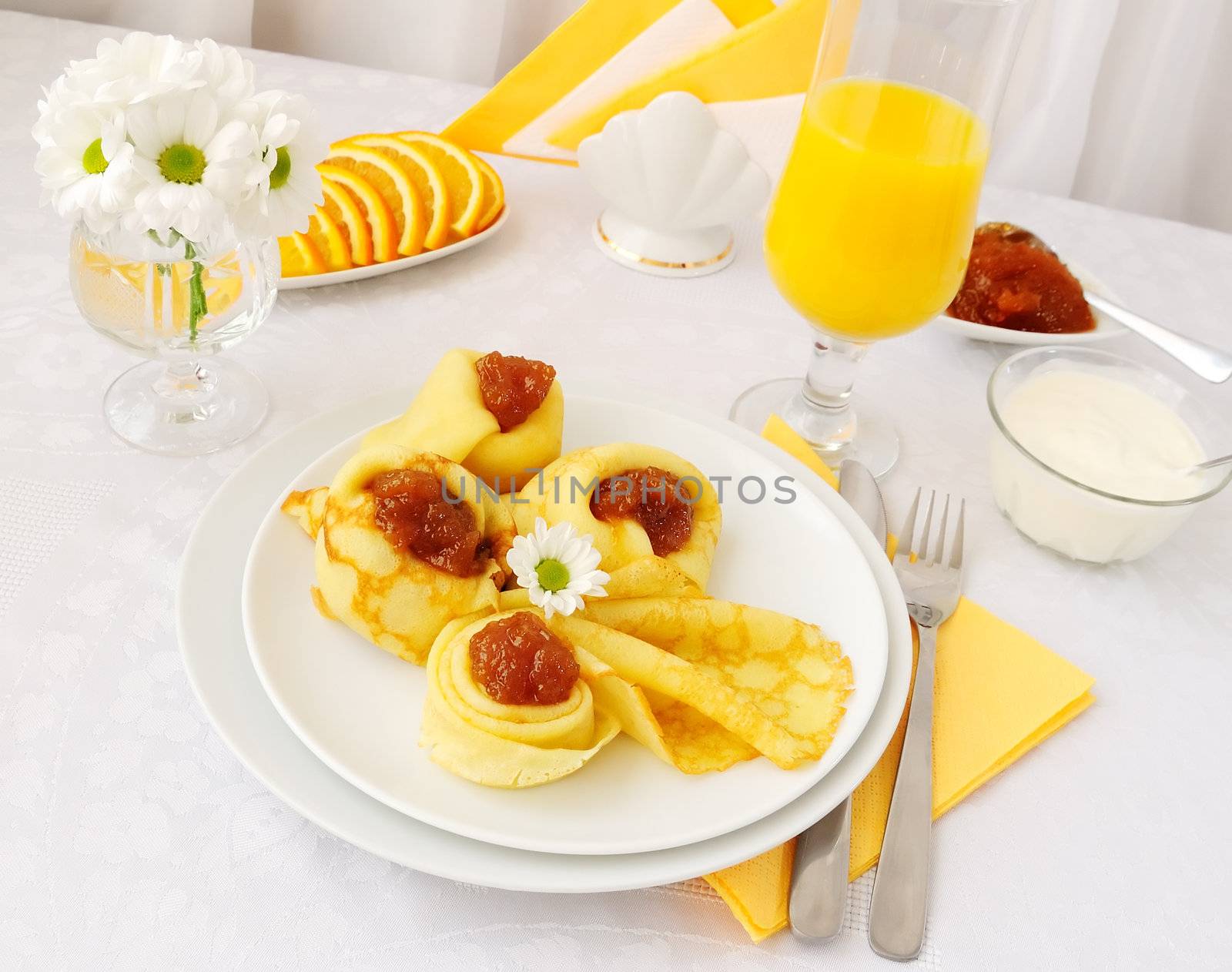 Breakfast with pancakes, apricot jam and orange juice