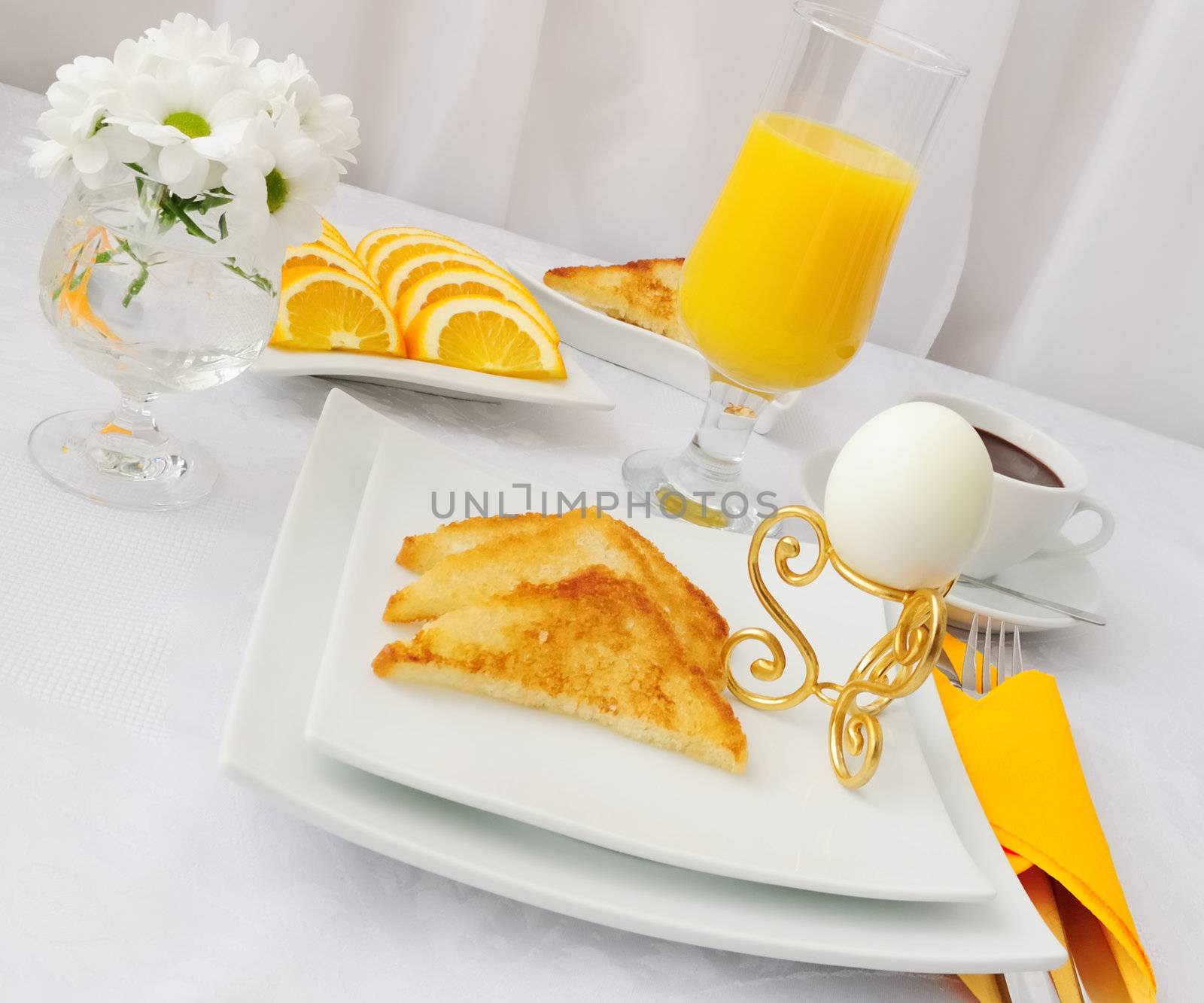  Breakfast with an egg on a stand with hot chocolate and orange juice