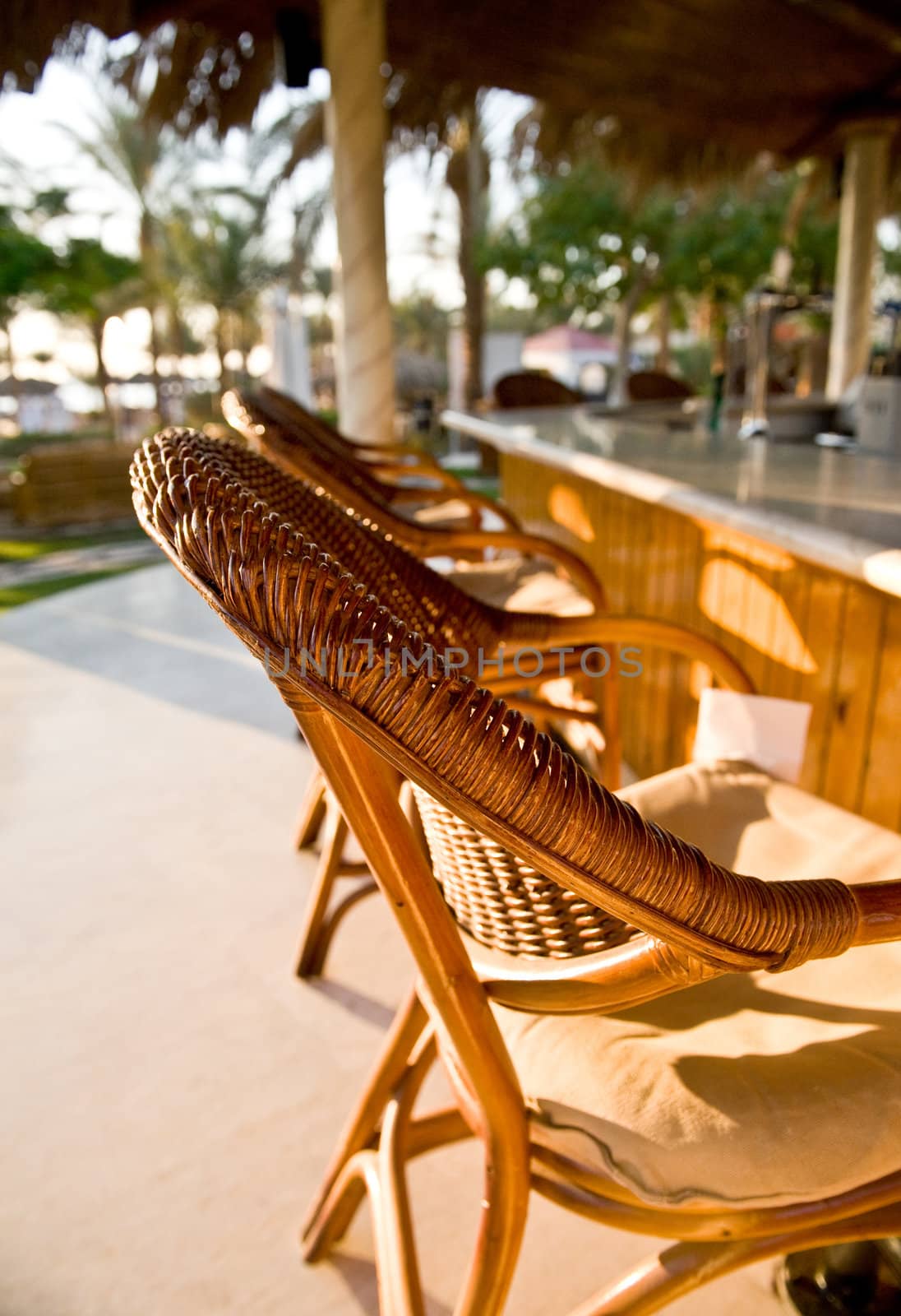 A wattled armchair waiting for someone who wants to have a rest in a summer cafe