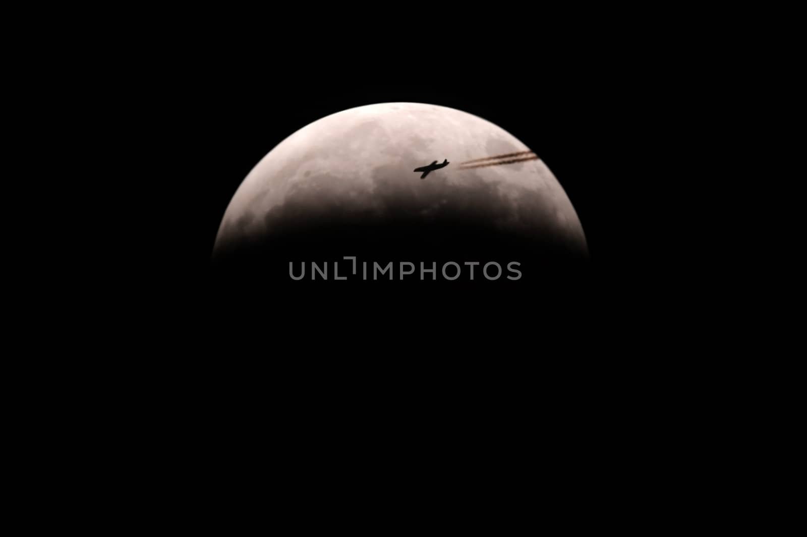 This image shows a snapshot from a half moon with airplane while any fractional 	lunar eclipse