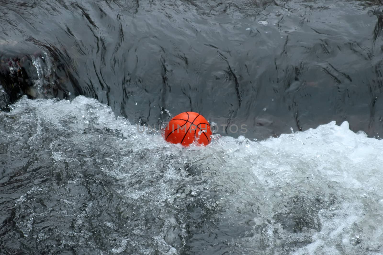 This image shows a basketball in a wild river