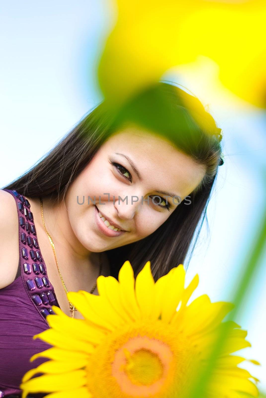 Young happy woman and sunflower. Shoot on the nature.