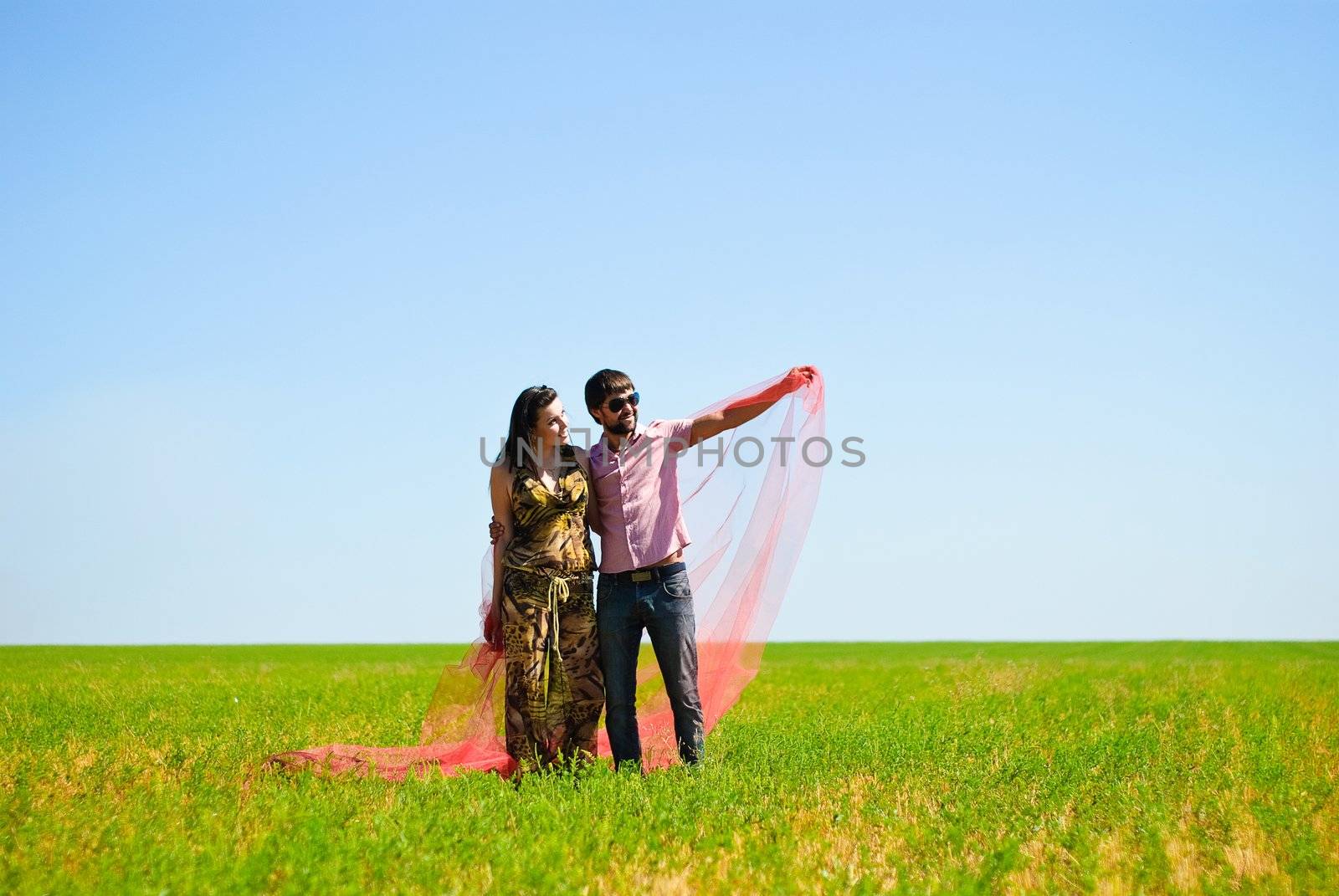 Young happy couple on the field. Shoot on the nature.