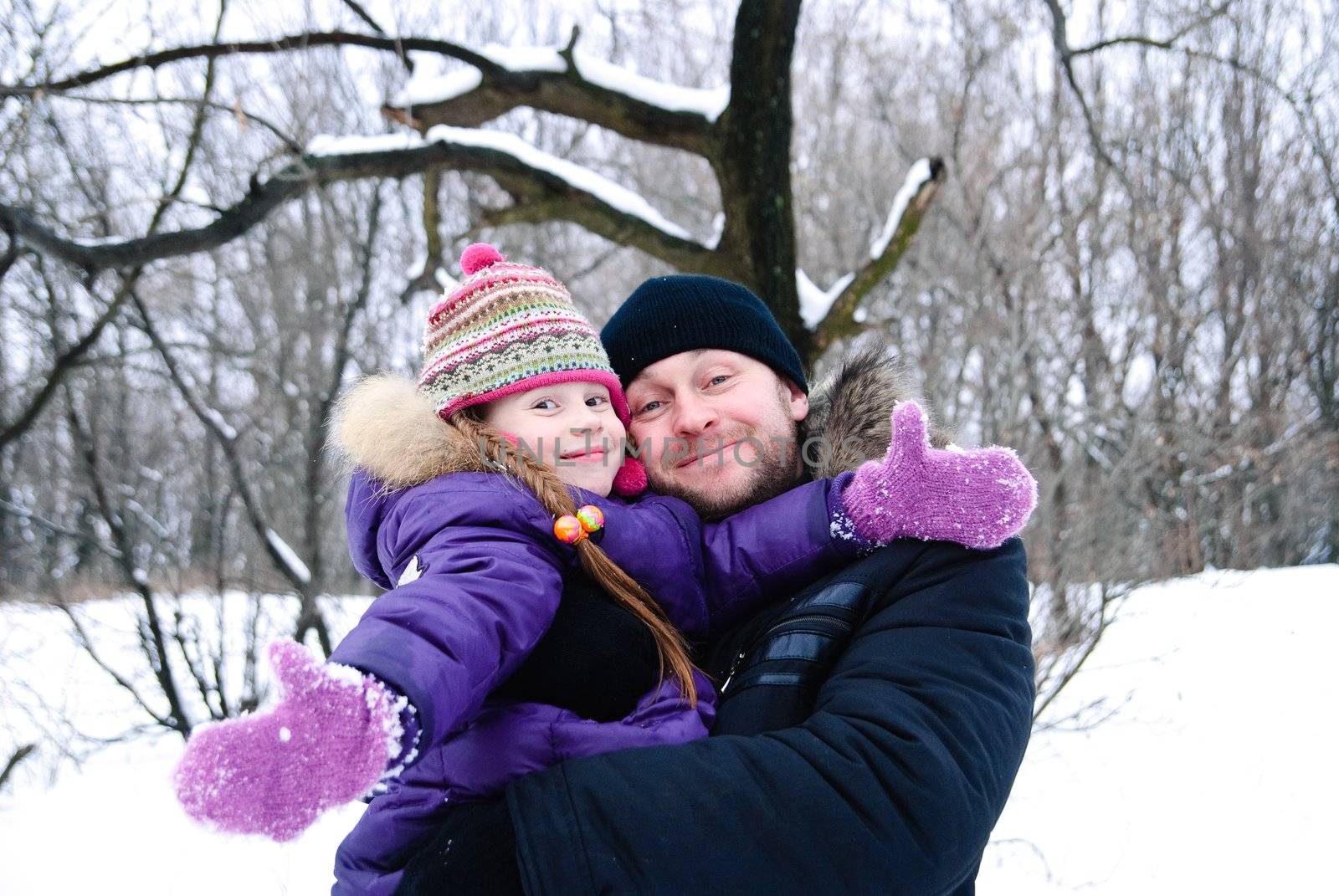 father and daughter in winter clothing in a winter woods