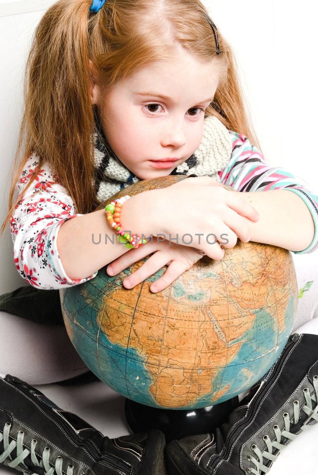 studio shot of pretty little girl with the globe