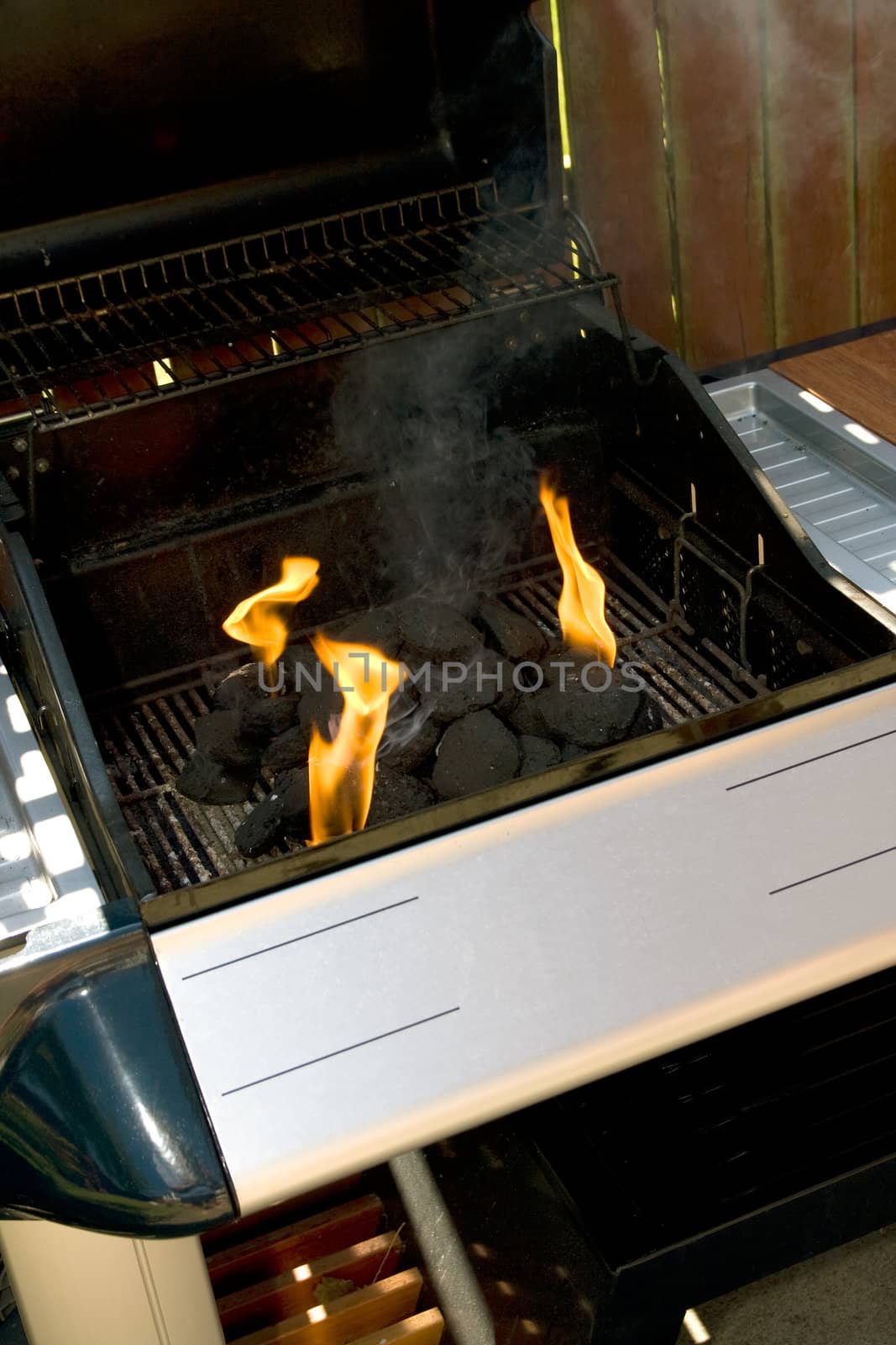Chrome and blue Barbecue fire with orange flames and black charcoal