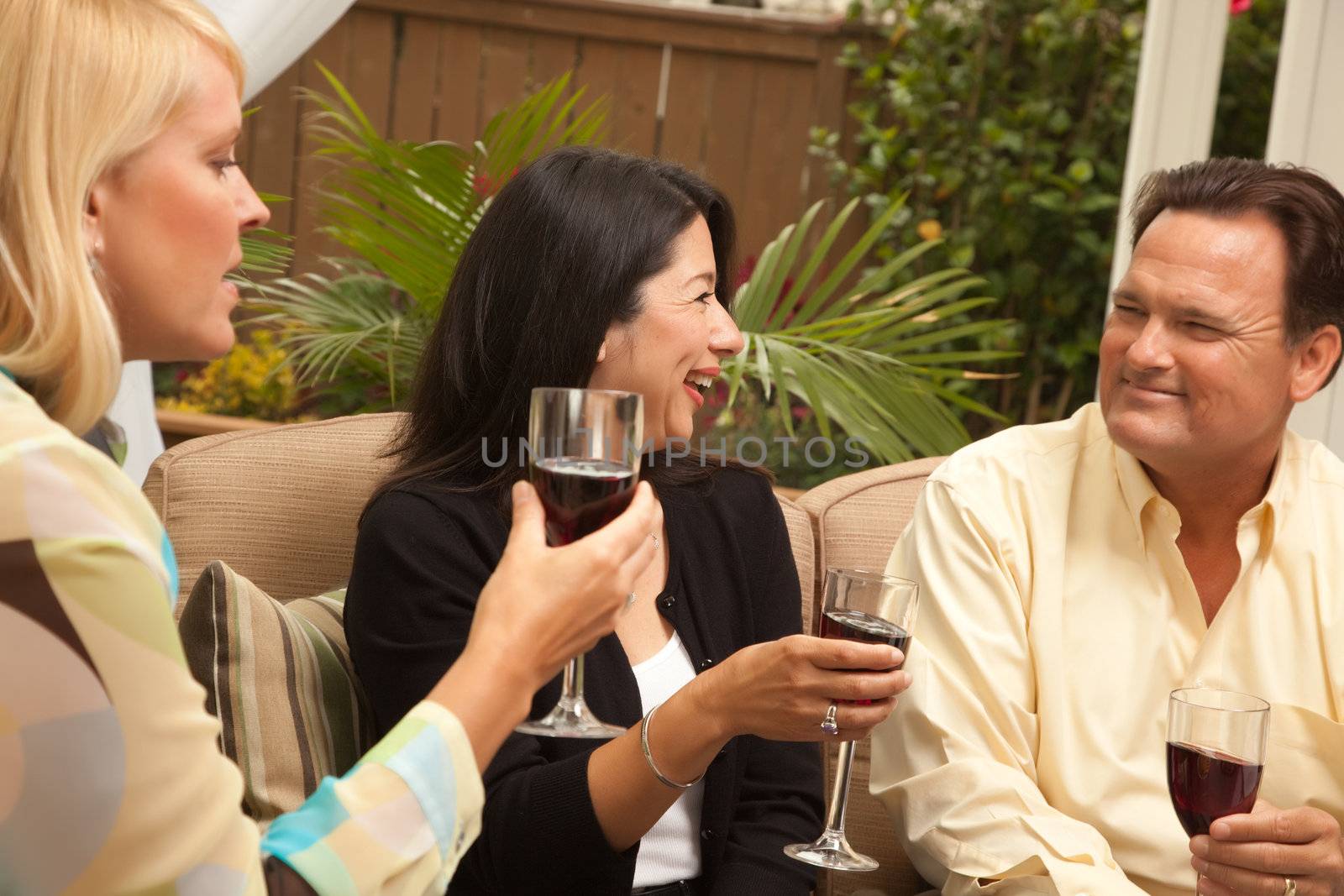 Three Friends Enjoying Wine on an Outdoor Patio.
