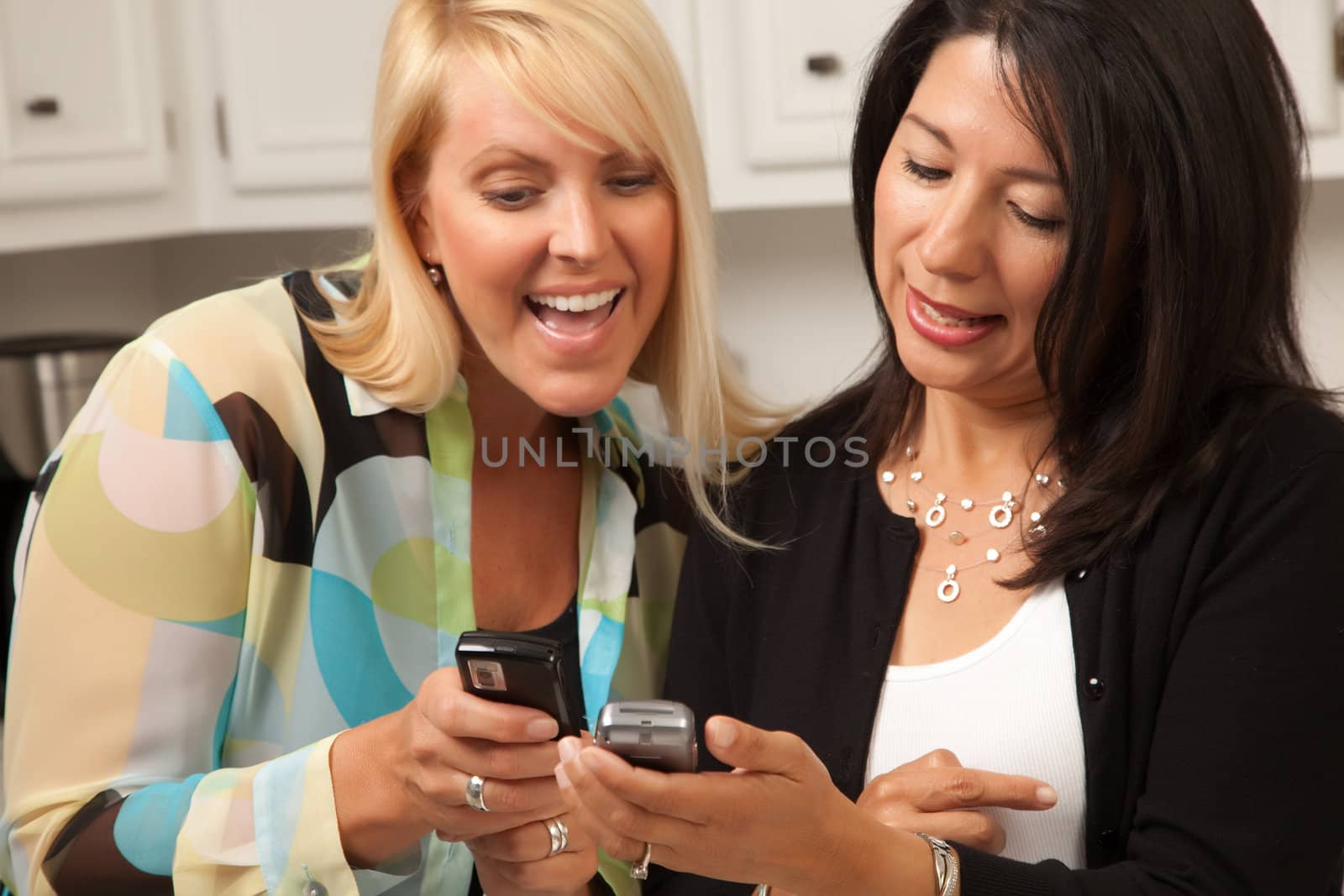 Two Girlfriends Sharing with Their Cell Phones by Feverpitched