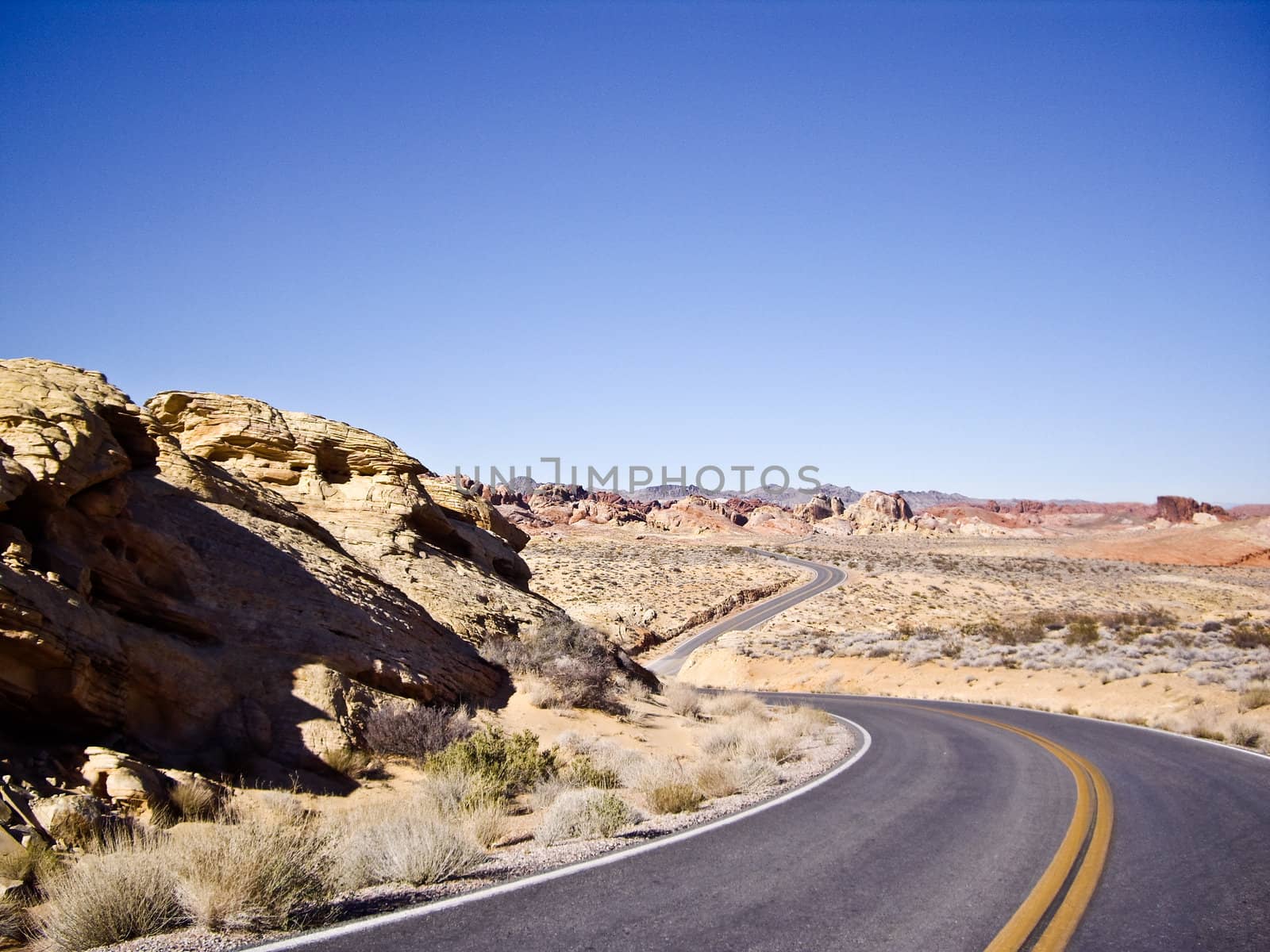 Long and winding desert road curves into the distance
