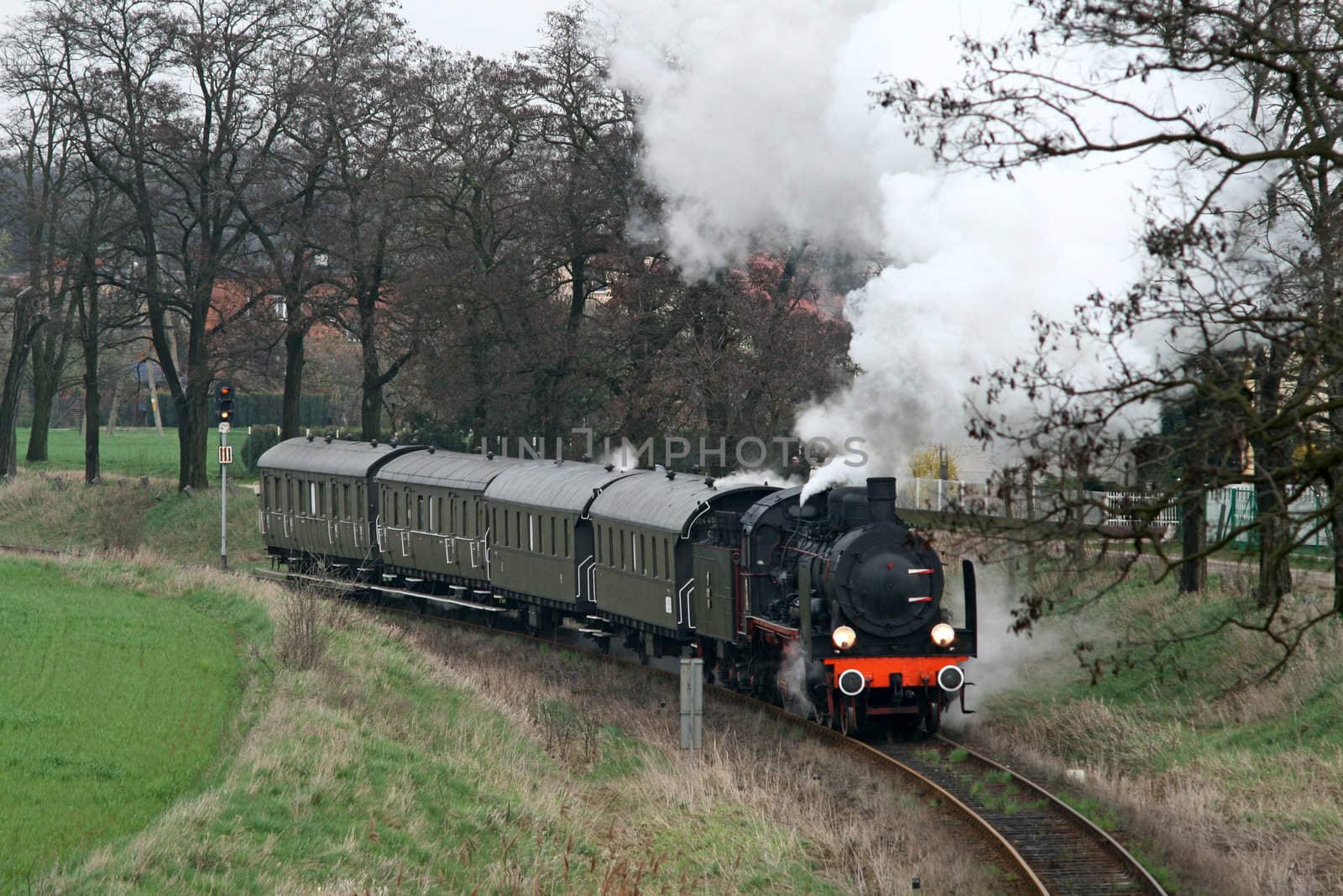 Old retro steam train passing the village