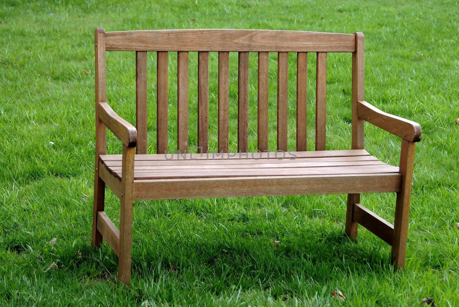 An empty park bench isolated against the grass background