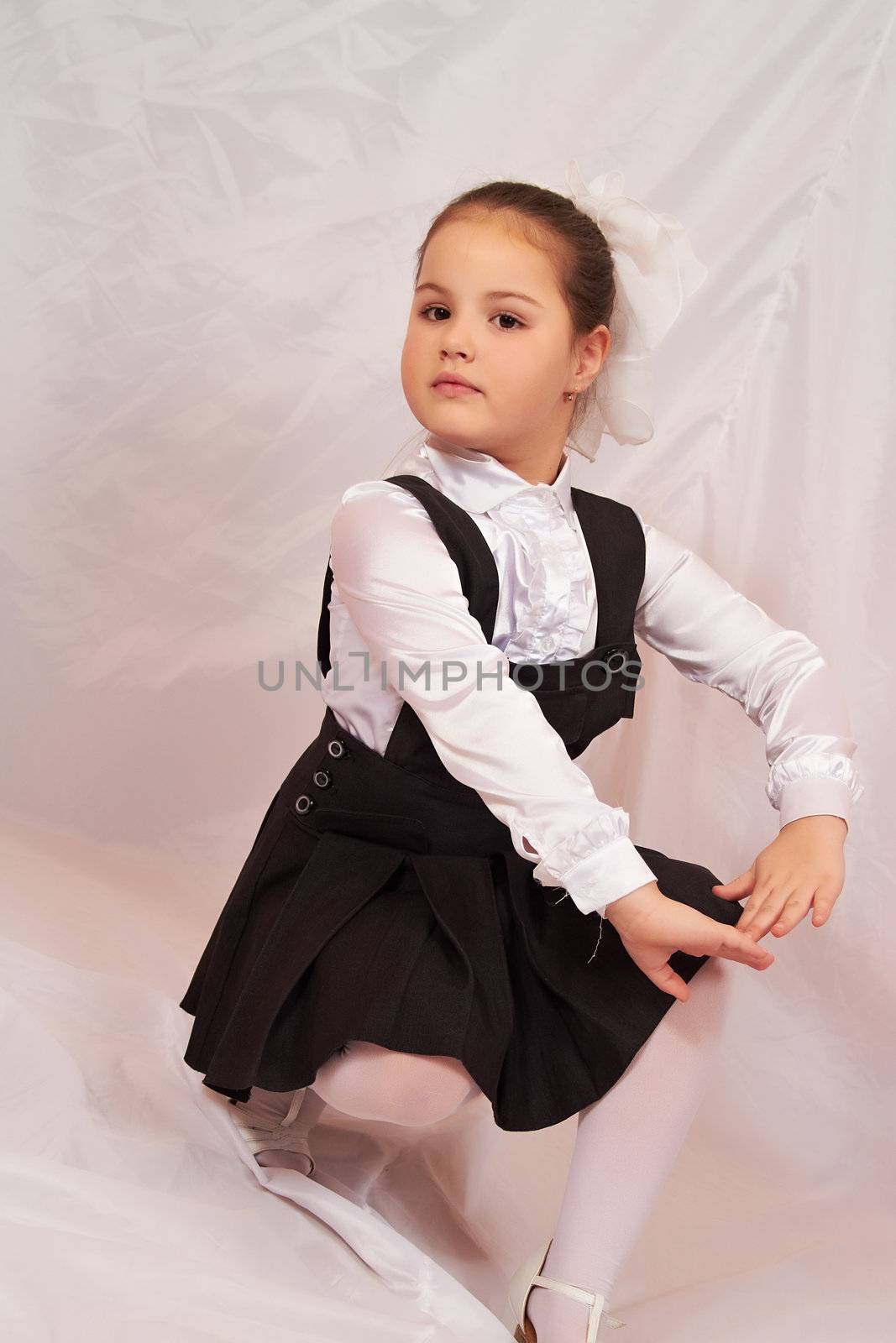 A little girl sits pensively.